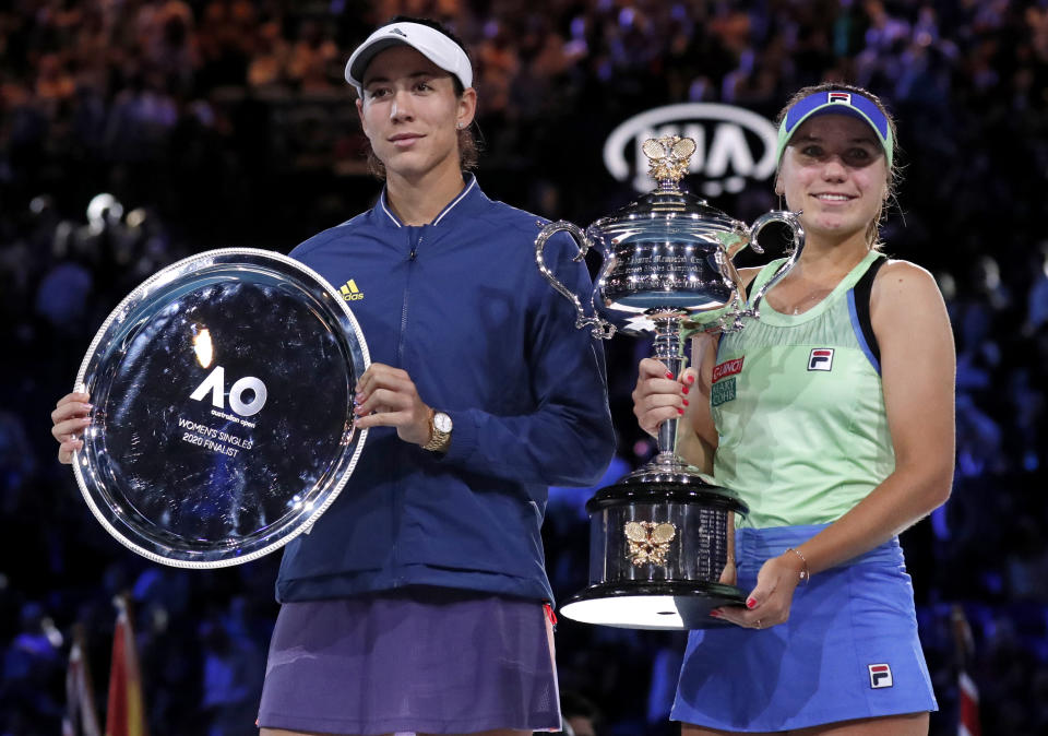 Sofia Kenin, right, of the U.S. holds the Daphne Akhurst Memorial Cup after defeating Spain's Garbine Muguruza in the women's singles final at the Australian Open tennis championship in Melbourne, Australia, Saturday, Feb. 1, 2020. (AP Photo/Lee Jin-man)