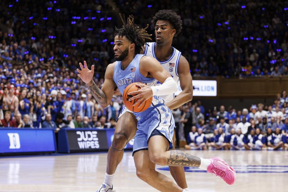 North Carolina's RJ Davis, left, drives as Duke's Sean Stewart, right, defends during the first half of an NCAA college basketball game in Durham, N.C., Saturday, March 9, 2024. (AP Photo/Ben McKeown)