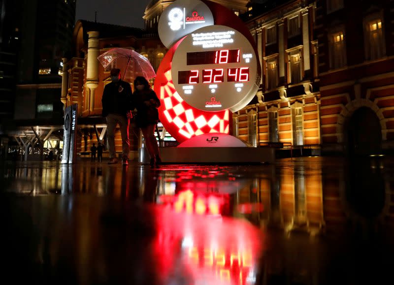 FILE PHOTO: Passersby walk past a countdown clock to the Tokyo 2020 Olympic Games, amid the coronavirus disease (COVID-19) outbreak in Tokyo