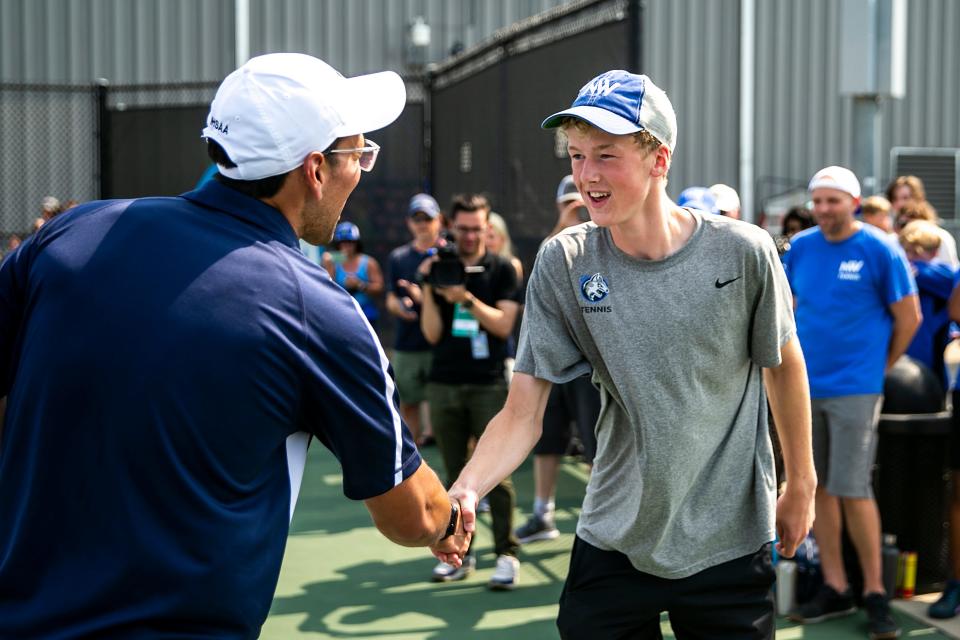 Waukee Northwest's Kaden Taylor is congratulated after winning the singles championship match during the Class 2A boys state tennis tournament against Ankeny Centennial on Wednesday at the Hawkeye Tennis &  Recreation Complex in Iowa City, Iowa.