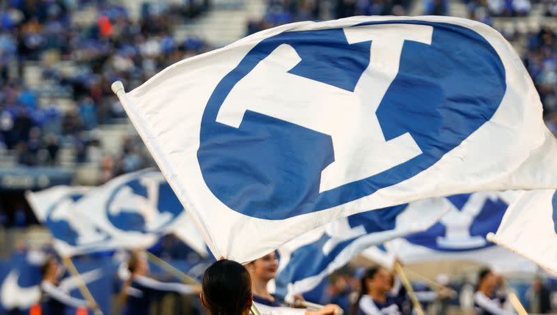 Cheerleaders wave flags at LaVell Edwards Stadium in Provo before a BYU football game on Friday, Oct. 28, 2022.