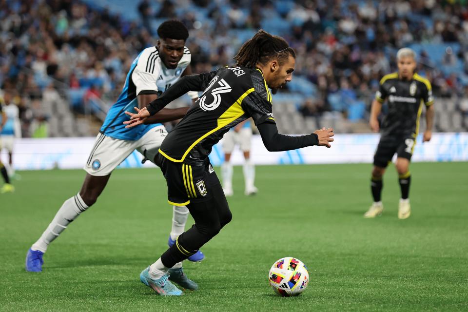 Mar 23, 2024; Charlotte, North Carolina, USA; Columbus Crew defender Mohamed Farsi (23) kicks the ball past Charlotte FC forward Iuri Tavares (38) at Bank of America Stadium. Mandatory Credit: Cory Knowlton-USA TODAY Sports