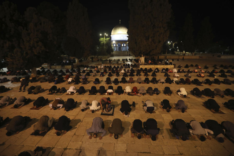 Muslim men pray next to the Dome of the Rock Mosque in the Al Aqsa Mosque compound in Jerusalem's old city, Sunday, May 31, 2020.The Al-Aqsa mosque in Jerusalem, the third holiest site in Islam, reopened early Sunday, following weeks of closure aimed at preventing the spread of the coronavirus. (AP Photo/Mahmoud Illean)