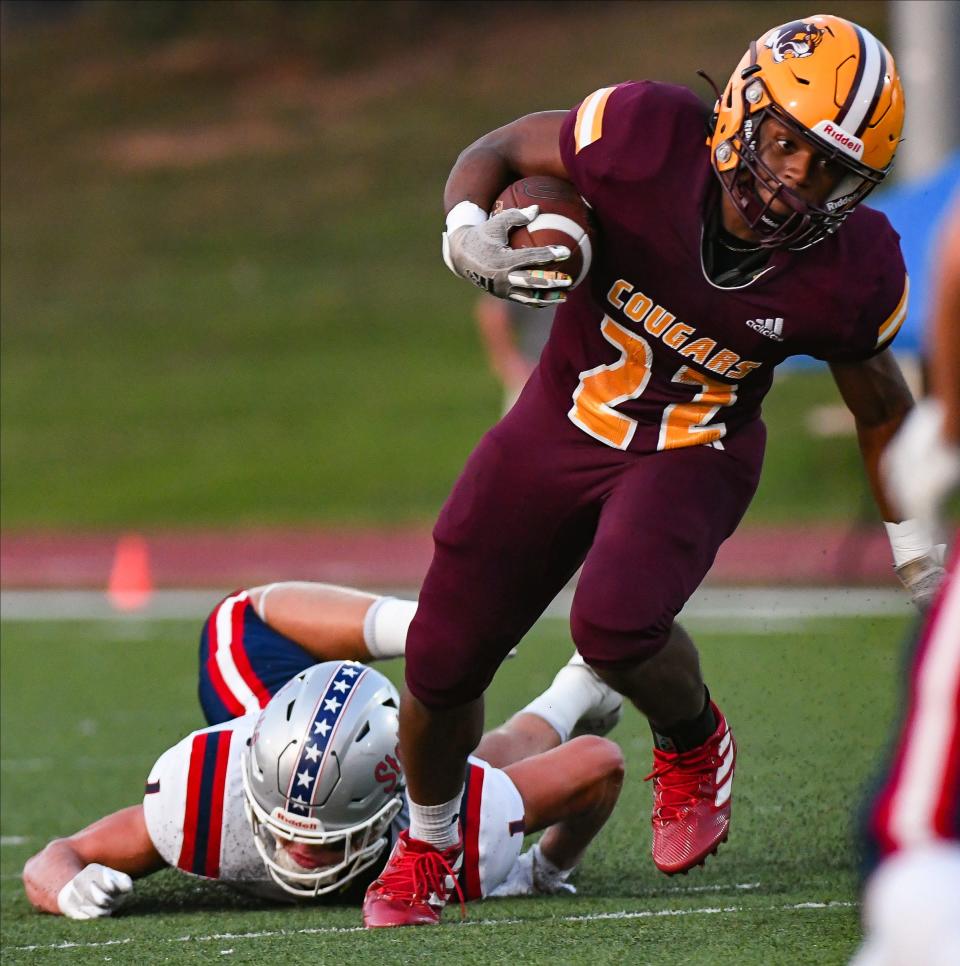 Bloomington North’s Kijuan Hayes (22) runs past a tackle attempt from BNL’s Braden Baker (1) during their football game at North on Friday, August 26, 2023.