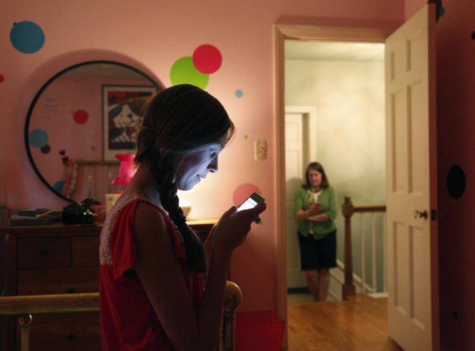 In this Thursday, May 24, 2012 photo, Anna Schiferl, foreground, texts her mother, Joanna, as they pose for a photograph in their LaGrange, Ill. home. Statistics from the Pew Internet & American Life Project show that, these days, many people with cell phones prefer texting over a phone call. It’s not always young people, though the data indicates that the younger you are, the more likely you are to prefer texting. But many experts say the most successful communicators will, of course, have the ability to do both talk or text, and know the most appropriate times to use those skills. (AP Photo/Charles Rex Arbogast)