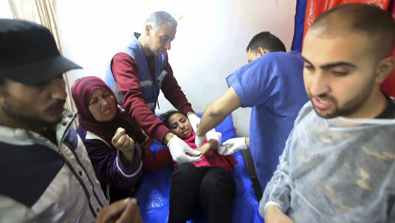 Palestinian medics treat a girl wounded in the Israeli bombardment at a building of a UNRWA vocational training center which displaced people use as a shelter in Khan Younis, southern Gaza Strip, on Wednesday, Jan. 24, 2024.