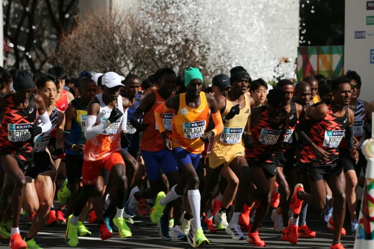 Elite male runners, including eventual winners Benson Kipruto (fourth from right) and Eliud Kipchoge (white cap) depart for the starting point of the Tokyo Marathon (Yue Chenxing)