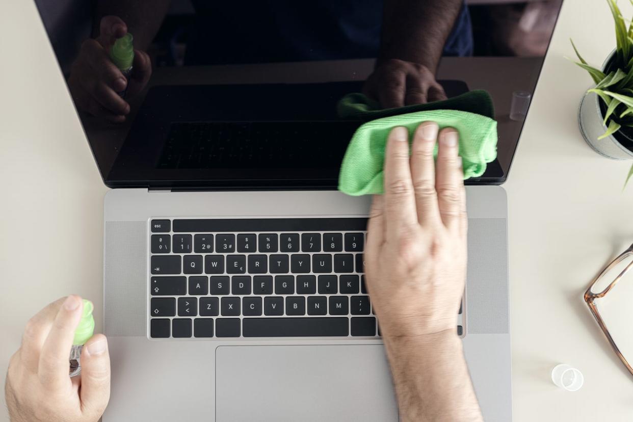 Man Cleaning a MacBook Screen