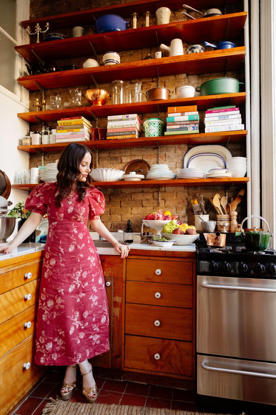 “It’s small, but it has a really nice energy,” Romilly Newman shares of her cozy, window-side kitchen. “I also love the open shelves because there’s so much height, I can store my books, plates, and various [finds].”