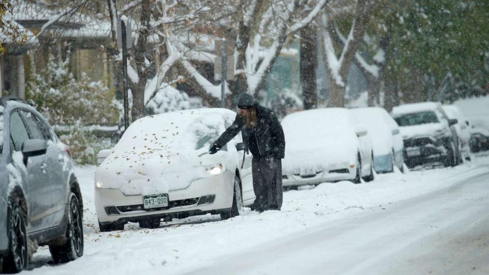 PHOTO: A motorist clears snow from a vehicle after a winter storm dumped up to a foot of snow in some Front Range communities, Oct. 29, 2023, in Denver. (David Zalubowski/AP)