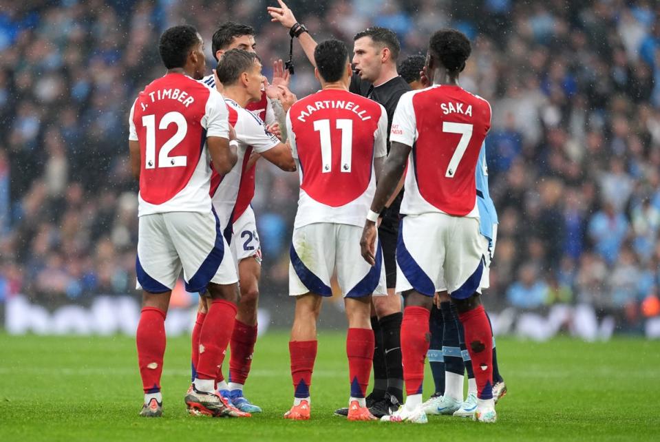 Leandro Trossard and Arsenal’s players complain to Michael Oliver (Martin Rickett/PA Wire)