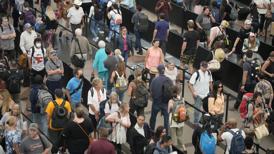 Travelers queue up at the south security checkpoint in Denver International Airport as the Labor Day holiday approaches,on Tuesday, August. 30, 2022. - David Zalubowski/AP