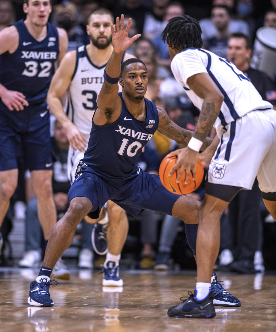 Xavier guard Nate Johnson (10) defends against Butler guard Jayden Taylor (13) during the first half of an NCAA college basketball game Friday, Jan. 7, 2022, in Indianapolis. (AP Photo/Doug McSchooler)
