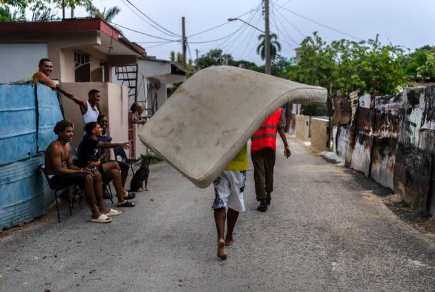 Residents of the El Fanguito neighborhood carry a mattress to a safe place in preparation for the arrival of Hurricane Ian in Havana, Cuba, on Monday. (Photo: Associated Press)