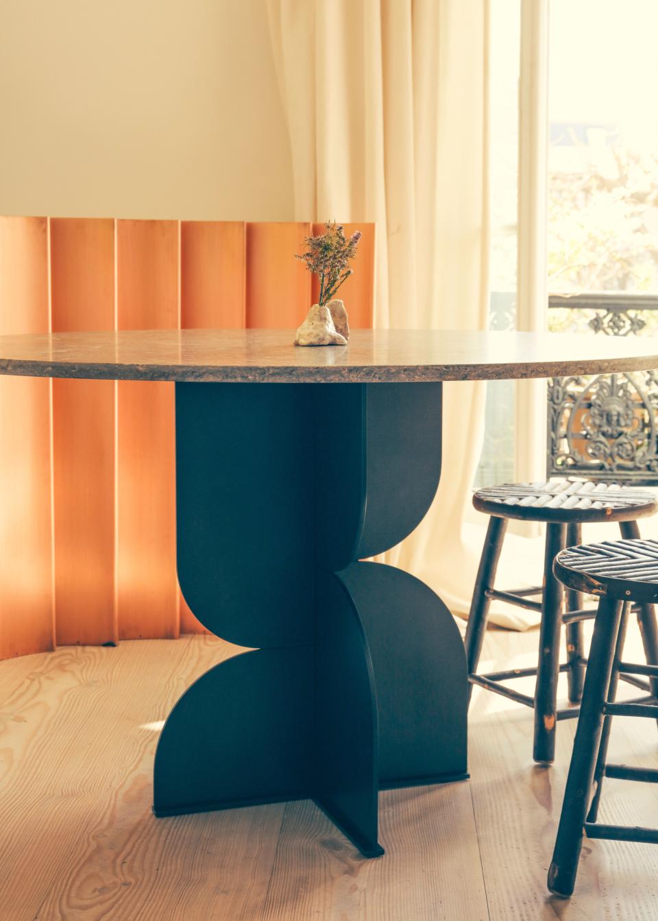 The screen in the background is by Champsaur for Pouenat Ferronnier, as is the steel table with a travertine top. The chestnut stools are custom.