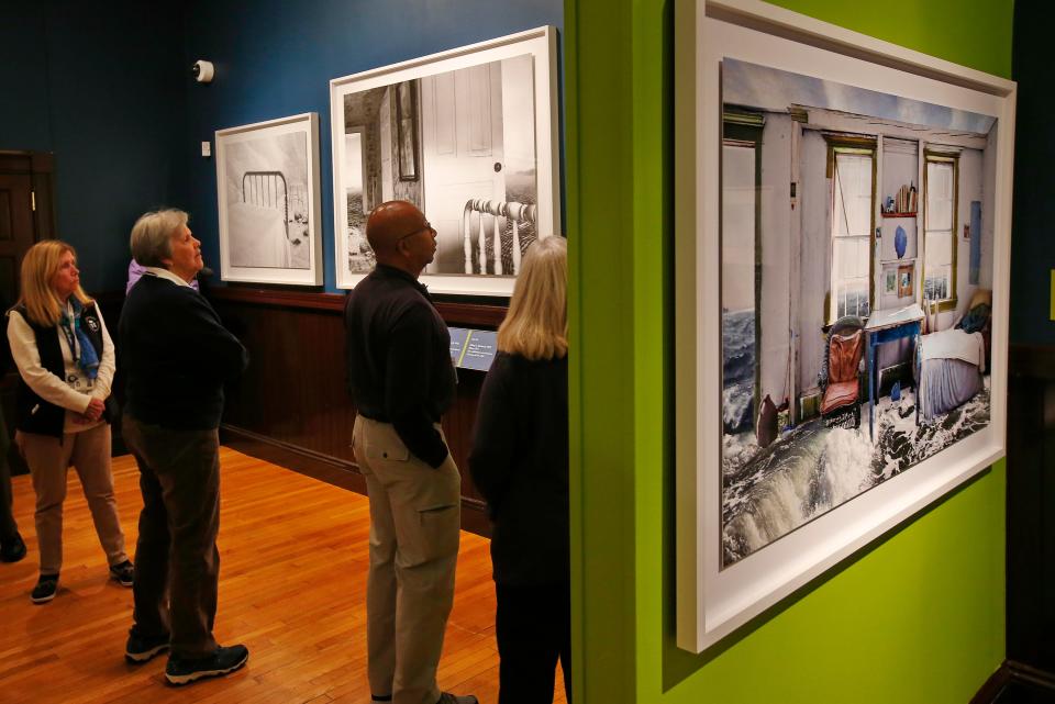 Visitors take a closer look at some of the photographic collages on display at the newly opened Framing the Domestic Sea photo collage exhibit by Jeffery C. Becton at the New Bedford Whaling Museum.