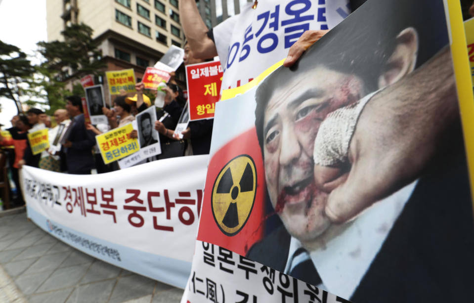 South Korean protesters with an image of Japanese Prime Minister Shinzo Abe stage a rally denouncing the Japanese government's decision on their exports to South Korea in front of the Japanese Embassy in Seoul, South Korea, Tuesday, July 23, 2019. Colonial-era Korean laborers have formally registered their request with a South Korean court to get its approval for the sale of local assets of their former Japanese employer. The signs read "Stop economic retaliation." (AP Photo/Ahn Young-joon)