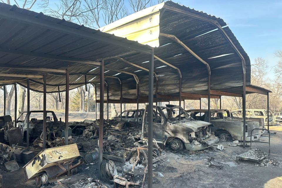 Burned cars rest in Richard Murray's garage outside of Canadian, Texas Wednesday, Feb. 28, 2024, after a wildfire passed near Canadian, Texas. A fast-moving wildfire burning through the Texas Panhandle grew into the second-largest blaze in state history Wednesday, forcing evacuations and triggering power outages as firefighters struggled to contain the widening flames. (AP Photo/Sean Murphy)