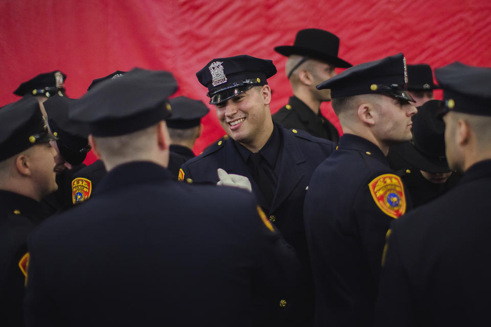 Matias Ferreira, center, celebrates with his colleagues during their graduation from the Suffolk County Police Department Academy at the Health, Sports and Education Center in Suffolk, N.Y., Friday, March 24, 2017. Ferreira, a former U.S. Marine Corps lance corporal who lost his legs below the knee when he stepped on a hidden explosive in Afghanistan in 2011, is joining a suburban New York police department. The 28-year-old graduated Friday from the Suffolk County Police Academy on Long Island following 29 weeks of training. (AP Photo/Andres Kudacki)