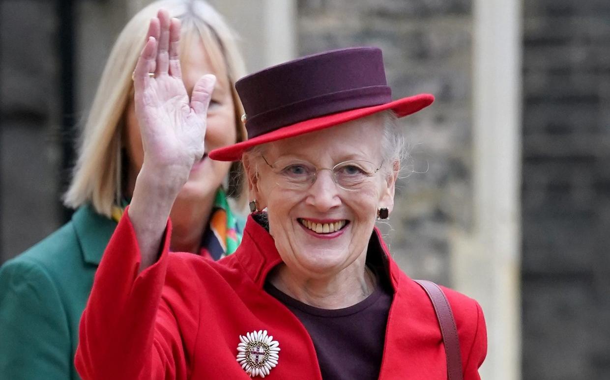 Queen Margrethe waves to camera, wearing red hat - Gareth Fuller/PA Wire