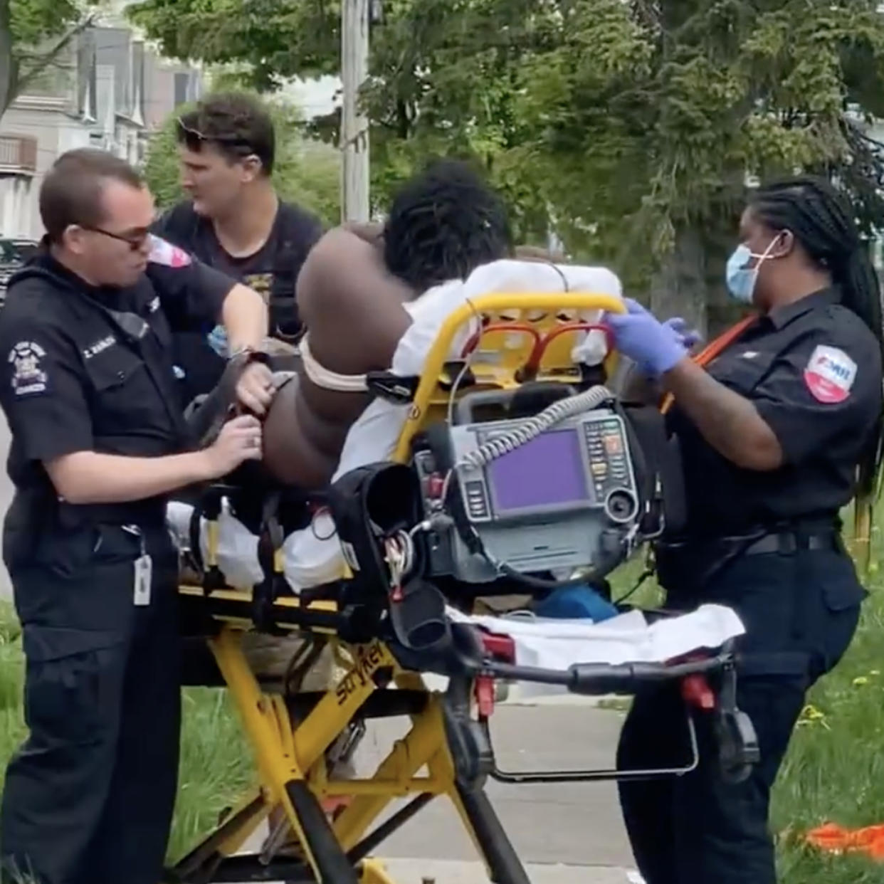 A man sits on a stretcher after a shooting in Buffalo (Tooy Johnson)