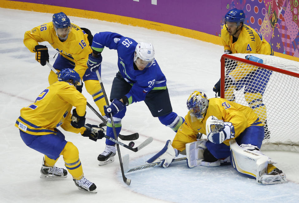 Sweden goaltender Henrik Lundqvist, right, blocks a shot attempt by Slovenia forward Jan Urbas in the second period of a men's ice hockey game at the 2014 Winter Olympics, Wednesday, Feb. 19, 2014, in Sochi, Russia. (AP Photo/Mark Humphrey)