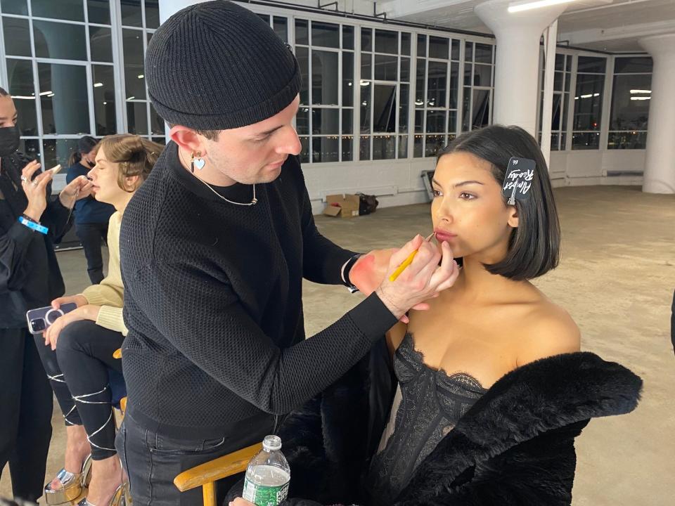 A model gets her makeup done for Christian Cowan's Fall/Winter 2023 show.