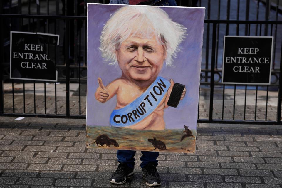 A protestor holds up a sign outside Downing Street (Copyright 2023 The Associated Press. All rights reserved)