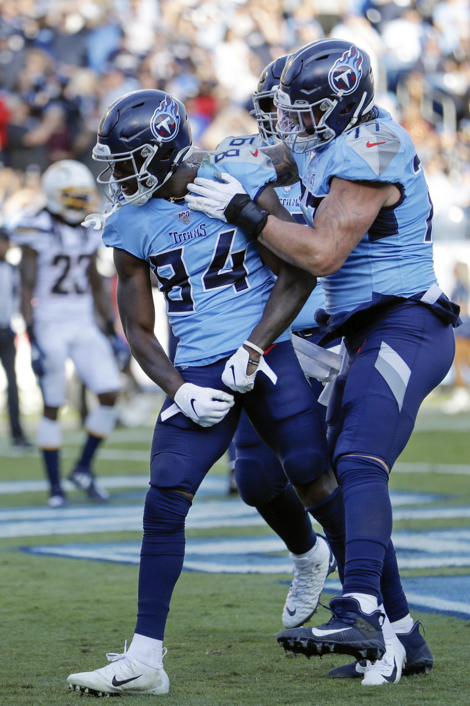 Tennessee Titans wide receiver Corey Davis (84) celebrates with offensive tackle Taylor Lewan (77) after Davis scored a touchdown against the Los Angeles Chargers in the first half of an NFL football game Sunday, Oct. 20, 2019, in Nashville, Tenn. (AP Photo/James Kenney)