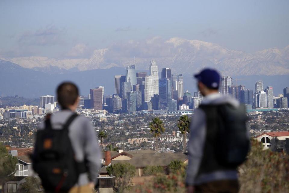 People looking over Los Angeles skyline with Mount Baldy beyond