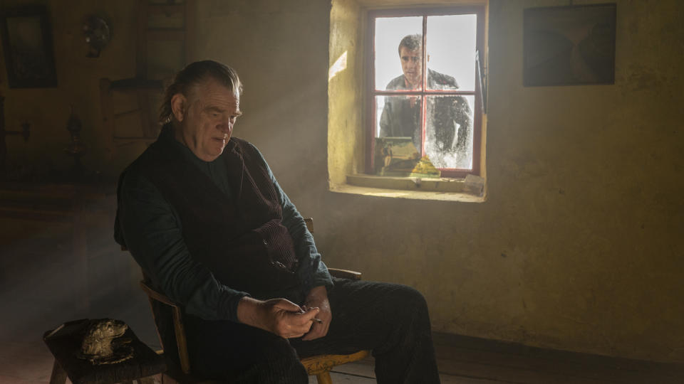 This image released by Searchlight Pictures shows Colin Farrell, in window, and Brendan Gleeson in "The Banshees of Inisherin." (Searchlight Pictures via AP)