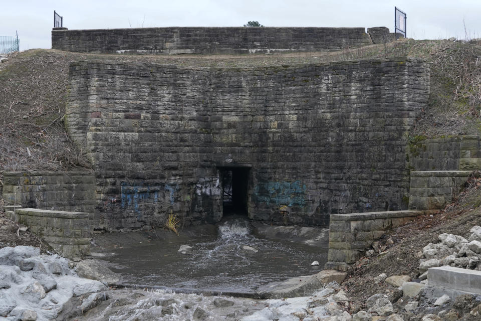 The dam holding back the water for Horseshoe Lake is shown, Tuesday, Dec. 7, 2021, in Cleveland Heights, Ohio. A pair of high-hazard dams built in the mid-1800s near Cleveland are among those in need of major repair. Upper Shaker Lake, commonly known as Horseshoe Lake, was drained as a precaution after it developed sinkholes and cracks. (AP Photo/Tony Dejak)