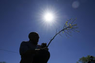 City arborist Todd Fagan plants a tree during a tree planting ceremony with school children, Friday, April 30, 2021, in Cedar Rapids, Iowa. A rare storm called a derecho plowed through the city of 130,000 last August with 140 mph winds and left behind a jumble of branches, downed powerlines and twisted signs. Now, city officials, businesses and nonprofit groups have teamed up with ambitious plans to somehow transform what is now a city of stumps back into the tree-covered Midwestern oasis along the Cedar River. (AP Photo/Charlie Neibergall)