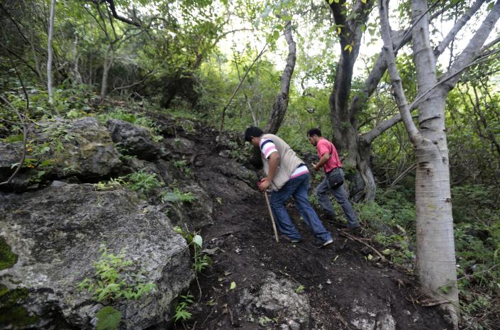 Local journalists look for graves in Pueblo Viejo, in the outskirts of Iguala, Guerrero state, Mexico, on October 6, 2014 (AFP Photo/Pedro Pardo)