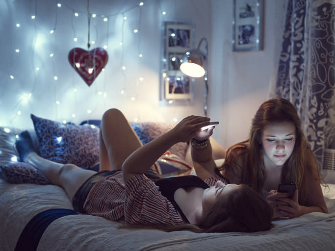 Sisters in their room on their phones