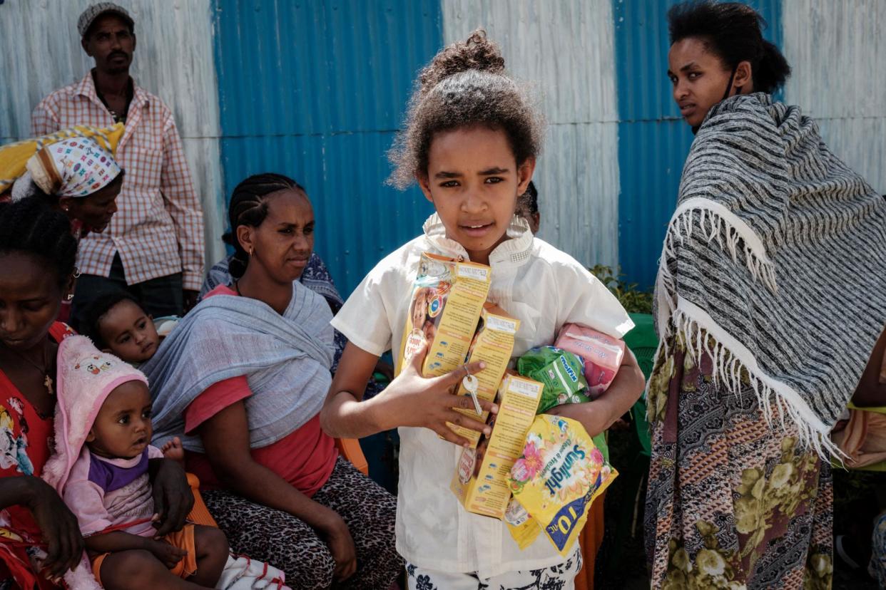 <span>One of the thousands of children displaced by the violence in Ethiopia helps carry items donated to her family in Mekelle, Tigray’s regional capital, in 2021.</span><span>Photograph: Yasuyoshi Chiba/AFP/Getty</span>