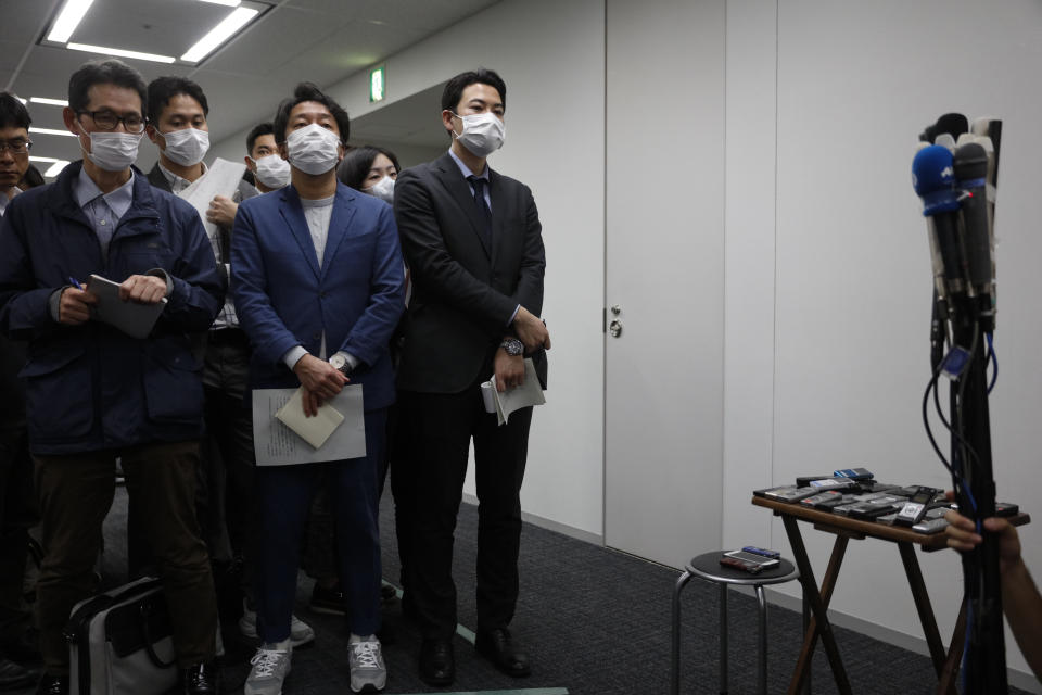 Reporters wearing masks wait for the start of a news conference with the Tokyo 2020 Organizing Committee's Toshiro Muto and Yoshiro Mori in Tokyo, Wednesday, March 4, 2020. The Olympic Games are under threat from a spreading virus from China that has reached the pandemic stage. (AP Photo/Jae C. Hong)