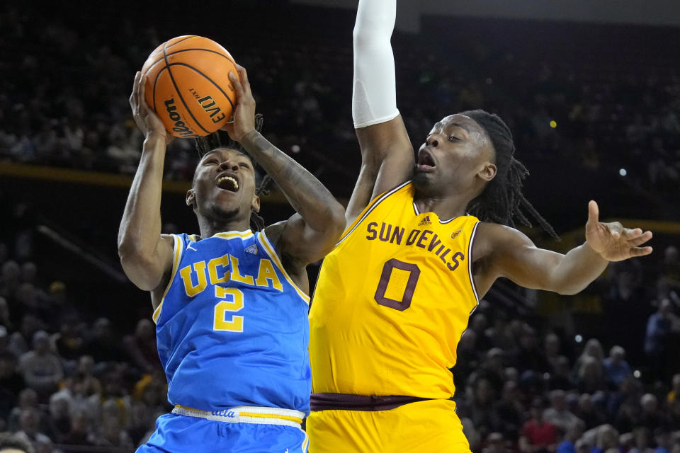 UCLA guard Dylan Andrews (2) drives past Arizona State guard Kamari Lands (0) during the first half of an NCAA college basketball game Wednesday, Jan. 17, 2024, in Tempe, Ariz. (AP Photo/Ross D. Franklin)