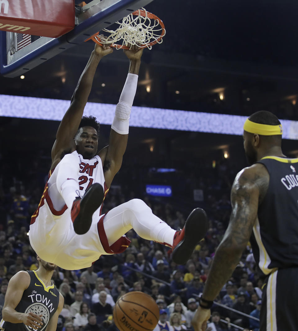 Miami Heat center Hassan Whiteside, left, scores in front of Golden State Warriors' DeMarcus Cousins during the first half of an NBA basketball game, Sunday, Feb. 10, 2019, in Oakland, Calif. (AP Photo/Ben Margot)