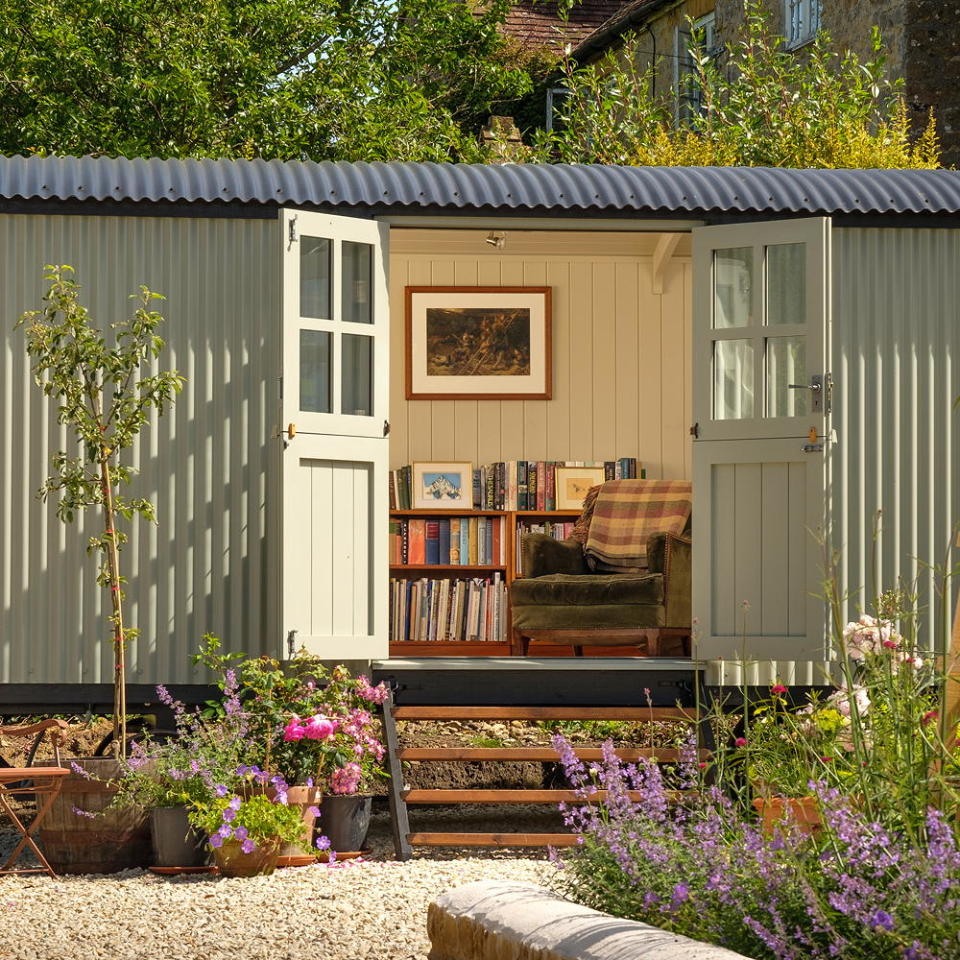 sage green shepherd's hut in garden