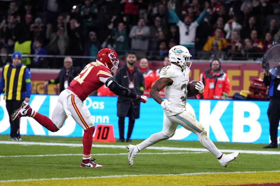 Miami Dolphins running back Raheem Mostert, right, scores on a 13-yard run past Kansas City Chiefs safety Mike Edwards (21) during the second half of an NFL football game Sunday, Nov. 5, 2023, in Frankfurt, Germany. (AP Photo/Martin Meissner)