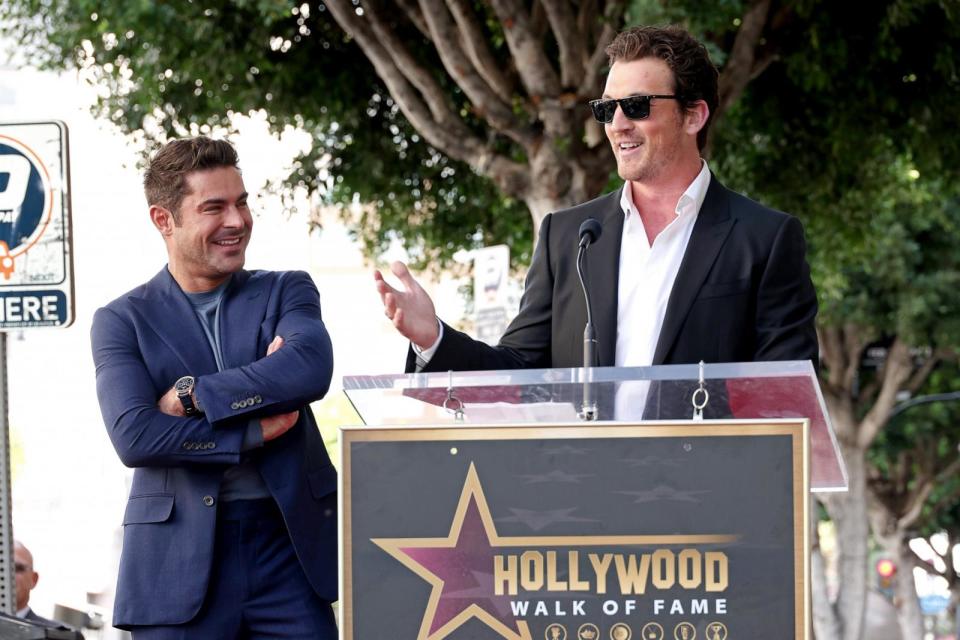 PHOTO: (L-R) Zac Efron and  Miles Teller speak onstage during the Hollywood Walk of Fame Star Ceremony Honoring Zac Efron on Dec. 11, 2023 in Hollywood, Calif. (Leon Bennett/Getty Images)