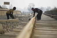 In this Nov. 29, 2018 photo, Nepalese construction laborers work at the terminal train station at Kurtha near Janakpur, Nepal from where a new rail line connects to Jay Nagar in the Indian state of Bihar. The competition between two Asian giants, India and China, for influence over tiny Nepal is yielding a bonanza in the form of the Himalayan mountain nation’s first modern railway, and possibly more to come. (AP Photo/Niranjan Shrestha)