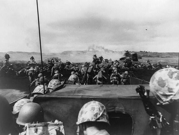 A wave of Fourth Division U.S. Marines charge ashore on Iwo Jima