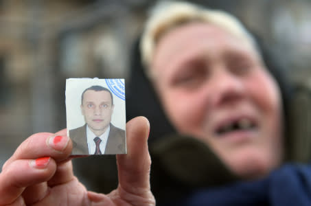The mother of two men, one of them, as she claims, was killed and the other one is missing, holds a picture of her lost son as she cries during a rally of mothers of the protesters in front of a policemen line facing anti-government opposition activists in the center of Kiev on January 31, 2014. Ukraine's military on Friday called on President Viktor Yanukovych to take "urgent steps" to ease turmoil in the country, weighing in for the first time on the ex-Soviet nation's worst crisis since independence. Ukrainian President Viktor Yanukovych on Friday signed a law offering an amnesty to jailed opposition activists and repealed controversial laws cracking down on protests, his office said. AFP PHOTO/ SERGEI SUPINSKY (Photo credit should read SERGEI SUPINSKY/AFP/Getty Images)