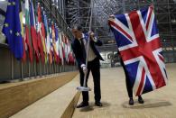 FILE PHOTO: Officials remove the British flag at EU Council in Brussels