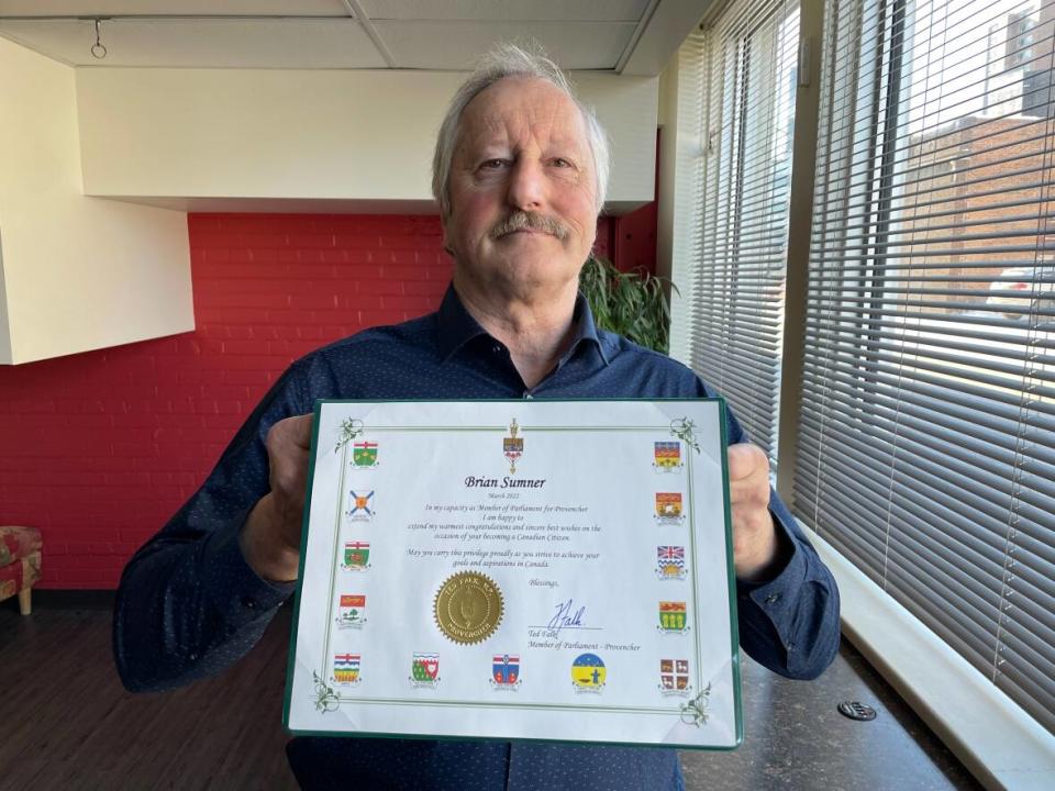 Brian Sumner, 66, holds the certificate he was given from his local MP after he thought he became a Canadian citizen. A technical snafu during his virtual citizenship ceremony meant the real certificate was actually shredded.   (Trevor Brine/CBC - image credit)