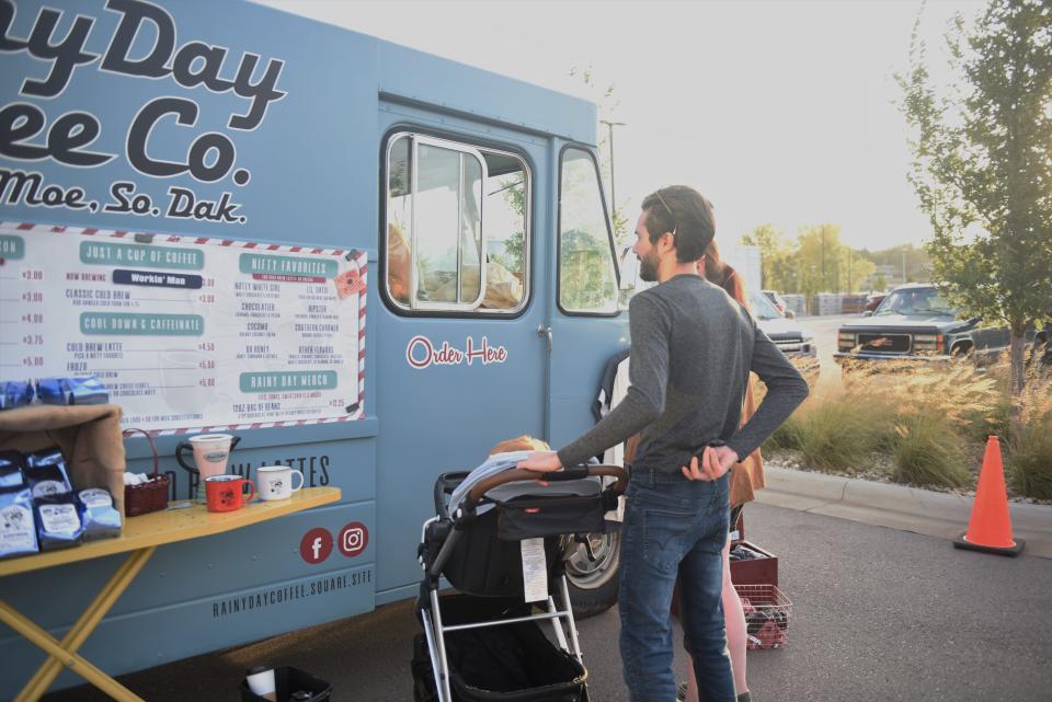 Cody and Katie Heisel look at the menu at the Rainy Day Coffee Co. truck at Lake Lorraine Farmer's Market