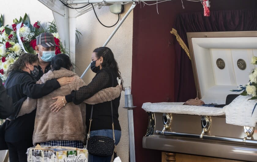 EAST LOS ANGELES, CA - DECEMBER 20: Family and friends console each other as they gather at a service for Julio Aguilar at the Continental Funeral Home on Sunday, Dec. 20, 2020 in East Los Angeles, CA. The 74-year-old died Nov 28, 2020 from complications of Covid-19.(Brian van der Brug / Los Angeles Times)