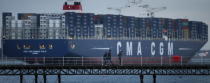 SOUTHAMPTON, ENGLAND - DECEMBER 10: People walk on a pier at Hythe as The Marco Polo, the world's biggest container ship, leaves Southampton on December 10, 2012 in England. On its first visit to Europe, the 54m (177ft) wide and 396m (1299ft) long container ship - which is 51m (167ft) longer than the Queen Mary II - will mostly carry consumer goods for delivery to shops for Christmas. (Photo by Peter Macdiarmid/Getty Images)